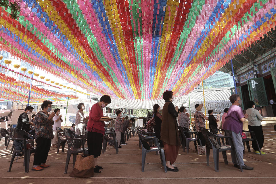 People wearing face masks to help protect against the spread of the new coronavirus pray while maintaining social distancing during a service at the Chogyesa temple in South Korea, Monday, June 22, 2020. (AP Photo/Ahn Young-joon)