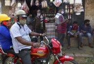 People wearing face masks as a precaution against the coronavirus shop at a market area in Bengaluru, India, Thursday, Oct. 29, 2020. India's confirmed coronavirus caseload surpassed 8 million on Thursday with daily infections dipping to the lowest level this week, as concerns grew over a major Hindu festival season and winter setting in. (AP Photo/Aijaz Rahi)