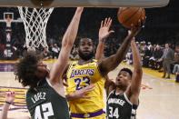 Los Angeles Lakers forward LeBron James, center, shoots as Milwaukee Bucks center Robin Lopez, left, and forward Giannis Antetokounmpo defend during the first half of an NBA basketball game Friday, March 6, 2020, in Los Angeles. (AP Photo/Mark J. Terrill)