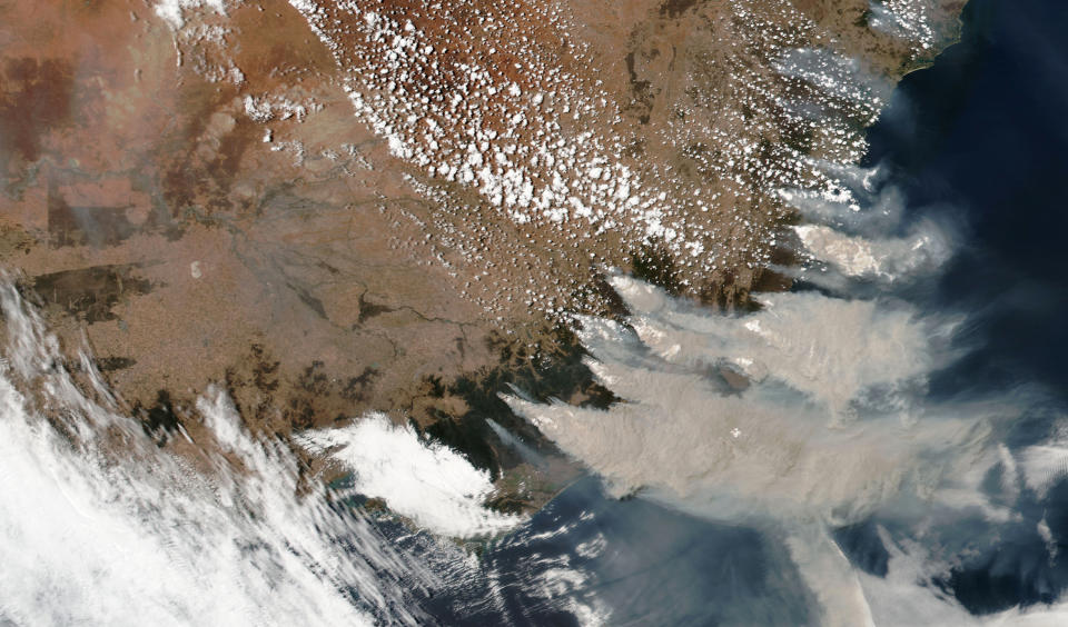 This satellite image provided by NASA on Saturday, Jan. 4, 2020 shows wildfires in Victoria and New South Wales, Australia. Australia's prime minister called up about 3,000 reservists on Saturday as the threat of wildfires escalated in at least three states, while strong winds and high temperatures were forecast to bring flames to populated areas including the suburbs of Sydney. (NASA via AP)