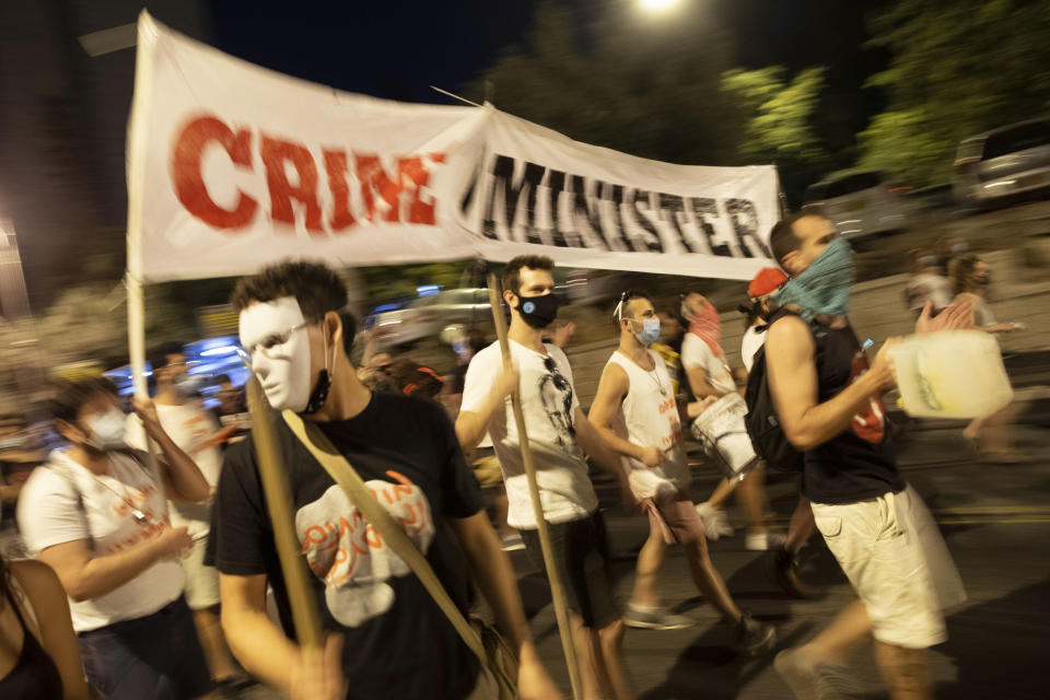 Demonstrators chant slogans and hold signs during a rally against Israel's Prime Minister Benjamin Netanyahu outside his residence in Jerusalem, Saturday, Aug 1, 2020. Protesters demanded that the embattled Israeli leader to resign as he faces a trial on corruption charges and grapples with a deepening coronavirus crisis. (AP Photo/Oded Balilty)