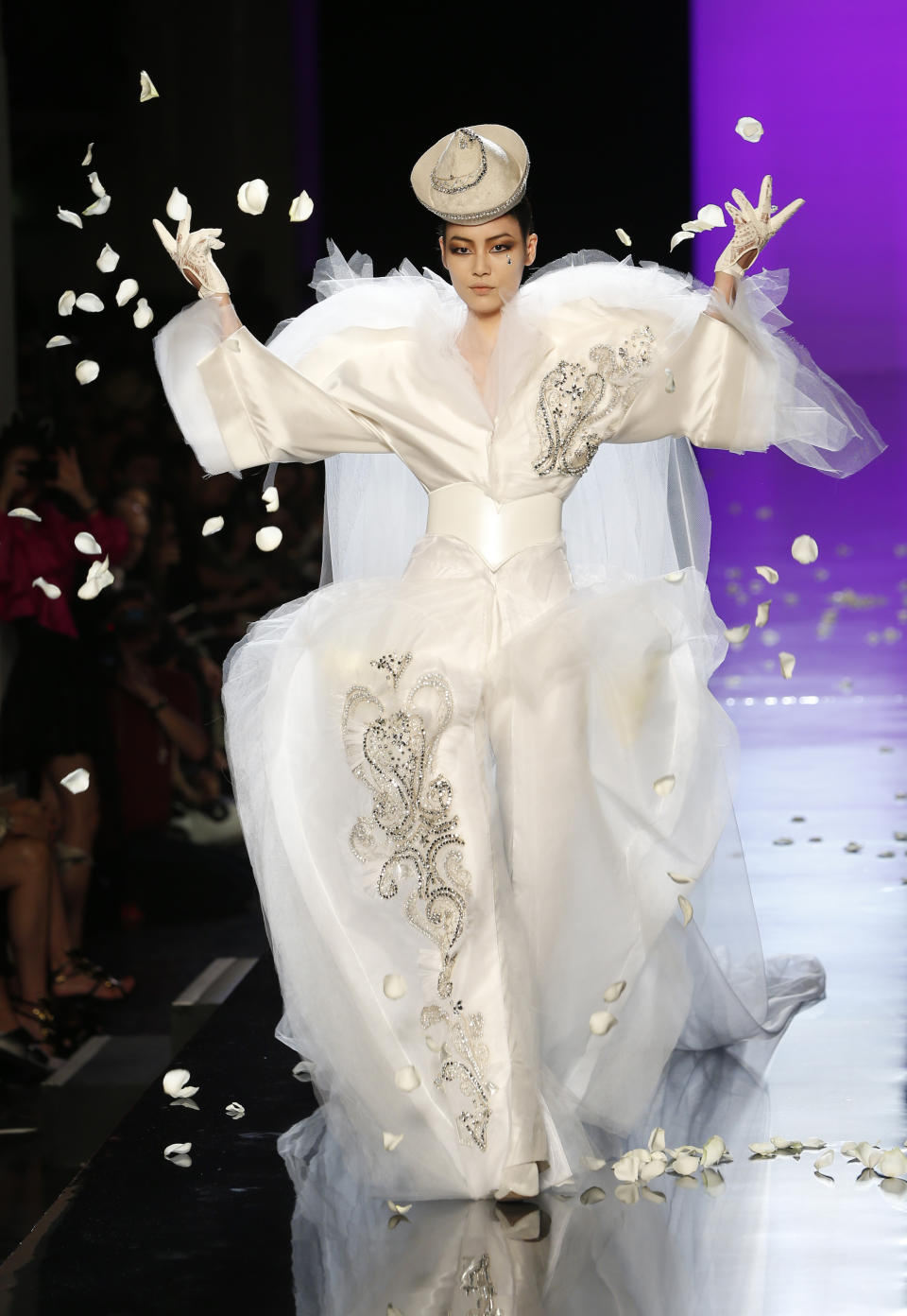 FILE - In this Wednesday, July 3, 2013 file photo, a model wears the wedding gown for Jean-Paul Gaultier's Haute Couture Fall-Winter 2013-2014 collection presented in Paris. Fashion icon Jean Paul Gaultier has announced his retirement from couture catwalk collections - the designer’s only remaining runway shoe since putting an end to his ready-to-wear collections in 2014. In a tweet, the ever-smiling and flamboyant 67-year-old said the couture show on Wednesday, Jan. 22, 2020 “celebrating 50 years of my career will also be my last.” He added: “But rest assured, haute couture will continue with a new concept.” (AP Photo/Jacques Brinon, file)