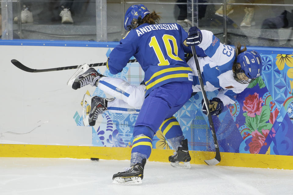 Emilia Anderson of Sweden pins Nina Tikkinen of Finland against the boards during the 2014 Winter Olympics women's ice hockey quarterfinal game at Shayba Arena, Saturday, Feb. 15, 2014, in Sochi, Russia. (AP Photo/Matt Slocum)