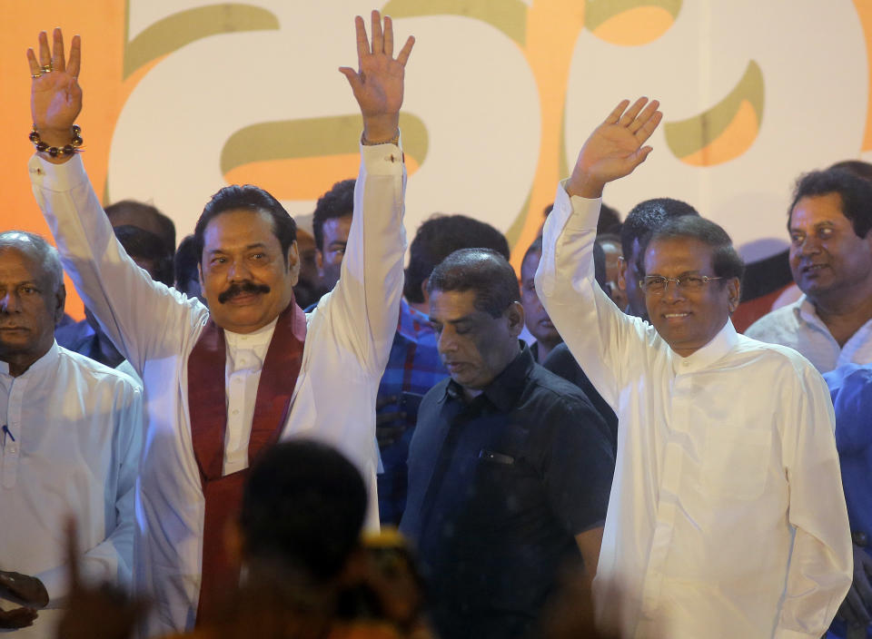 FILE- In this Monday, Nov. 5, 2018, file photo, Sri Lankan president Maithripala Sirisena, right, and his newly appointed prime minister Mahinda Rajapaksa wave to supporters during a rally held out side the parliamentary complex in Colombo, Sri Lanka. Sri Lankan is in the midst of a political crisis set off by the president's decisions to remove the South Asian island nation's prime minister, dissolve Parliament and call snap elections. The moves have triggered public protests and international criticism, including from some of the country's biggest donors. (AP Photo/Eranga Jayawardena, file)