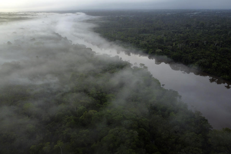 Fog hovers over the Guama River in the Tenetehar Wa Tembe village in the Alto Rio Guama Indigenous territory, in Paragominas municipality, in Para state, Brazil, as the sun rises Saturday, June 10, 2023. Renowned for its beauty and biodiversity, the life-giving nutrients of the forest are mostly stored in the trees and other plants, not the soil. (AP Photo/Eraldo Peres)