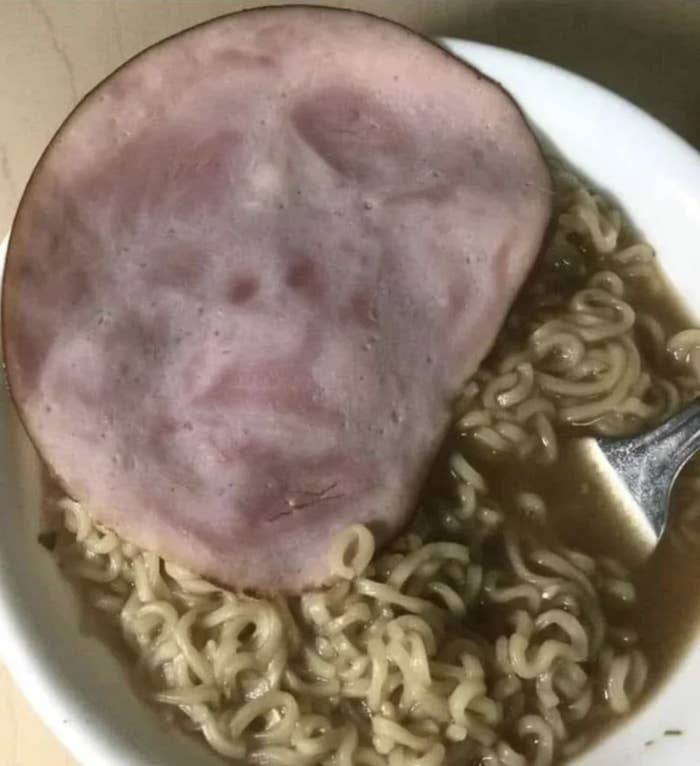 a slice of ham on a bowl of ramen