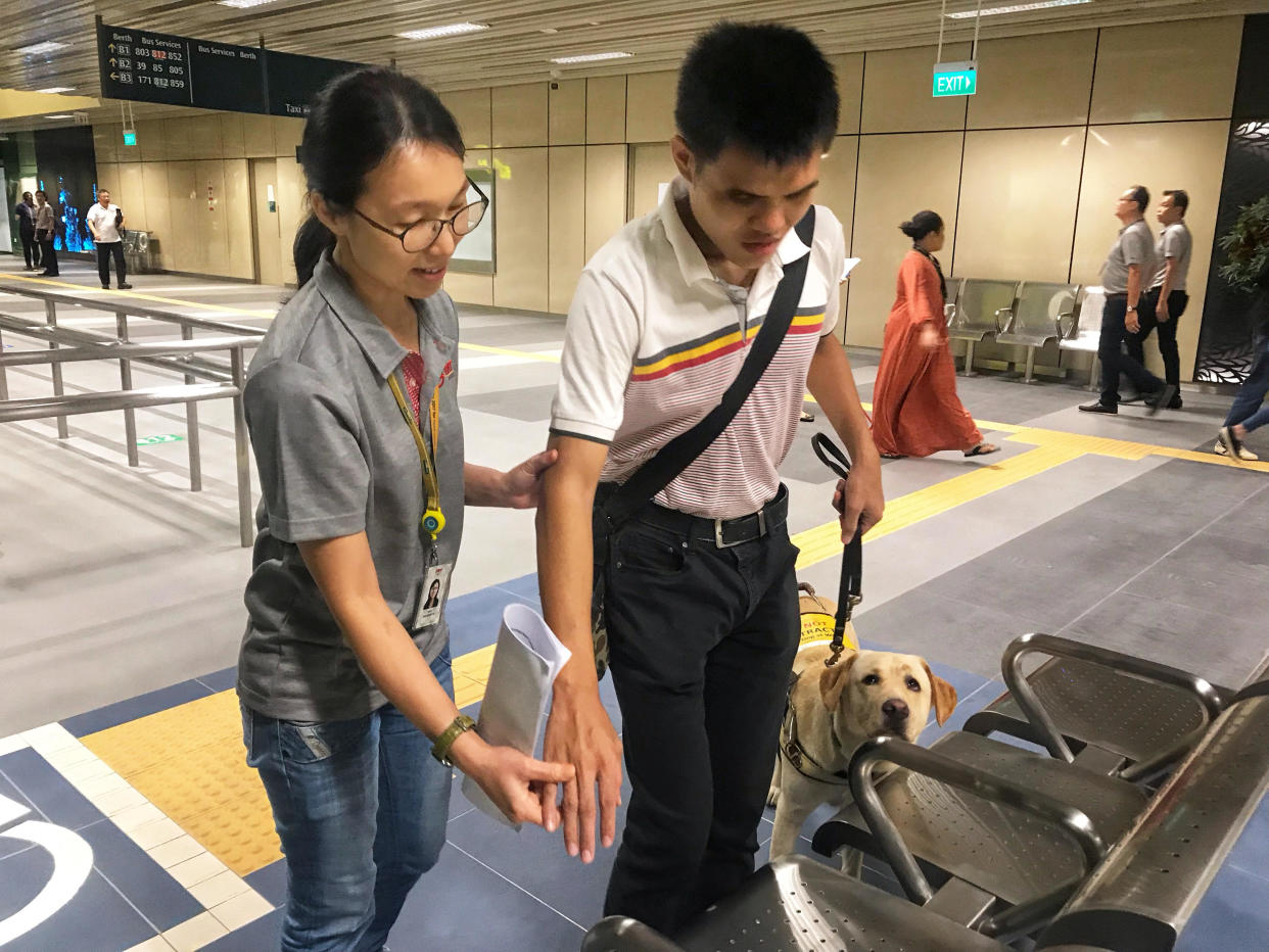 An SMRT Buses staff member aiding a visually-impaired commuter with a guide dog at the upcoming Yishun Integrated Transport Hub on 23 August, 2019. (PHOTO: SMRT)