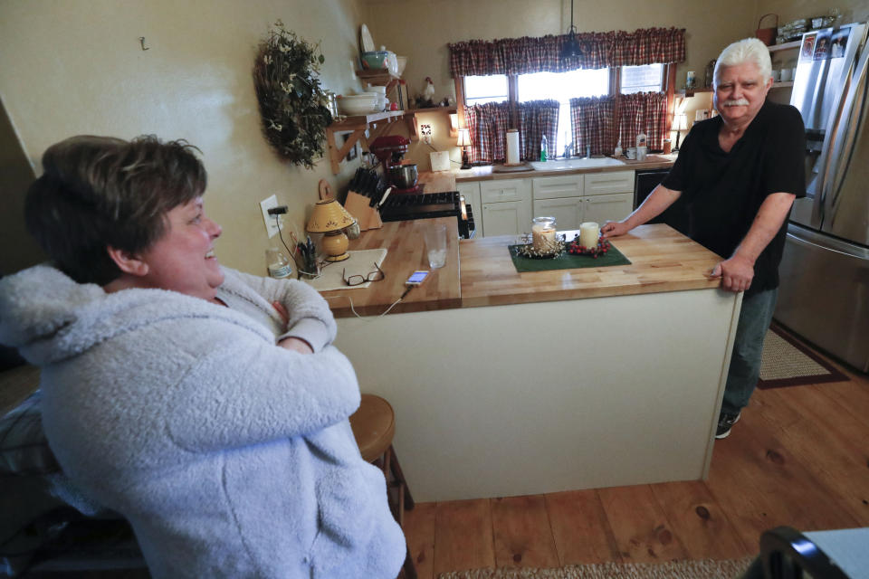 In this April 8, 2019, photo Chuck Pope, right, and wife Nina talk about his ongoing battle with rheumatoid arthritis and trying to afford medications to alleviate the condition while at their home in Derry, Pa. While he was still working, his insurance covered an injected drug that relieves pain and stops irreversible joint damage but retails for over $5,000 a month. Now his Medicare plan doesn't cover the drug, and Pope says his condition is deteriorating without it. Meanwhile, sales of approved, cheaper versions have been blocked. (AP Photo/Keith Srakocic)