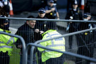 Police officers detain a man after he entered the grounds of the Houses of Parliament in London, Wednesday, Dec. 1, 2021. (AP Photo/David Cliff)