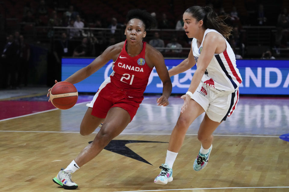 Canada's Nirra Fields, left, runs past France's Marine Fauthoux during their game at the women's Basketball World Cup in Sydney, Australia, Friday, Sept. 23, 2022. (AP Photo/Mark Baker)
