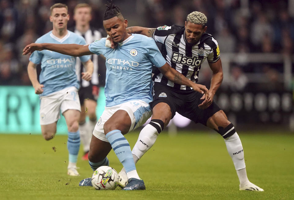 Manchester City's Manuel Akanji, left, and Newcastle United's Joelinton, right, battle for the ball during the English League Cup soccer match between Newcastle United and Manchester City in Newcastle upon Tyne, England, Wednesday, Sept. 27, 2023. (Owen Humphreys/PA via AP)