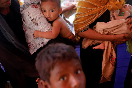 Rohingya refugees who arrived by boat fleeing violence in Myanmar the night before, wait to receive some aid at a relief centre at Teknaf near Cox's Bazar, Bangladesh October 4, 2017. REUTERS/Damir Sagolj