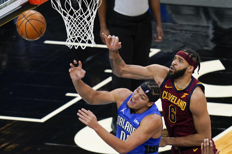 Orlando Magic forward Aaron Gordon, left, is fouled by Cleveland Cavaliers center JaVale McGee (6) as he goes up for a shot during the first half of an NBA basketball game, Wednesday, Jan. 6, 2021, in Orlando, Fla. (AP Photo/John Raoux)