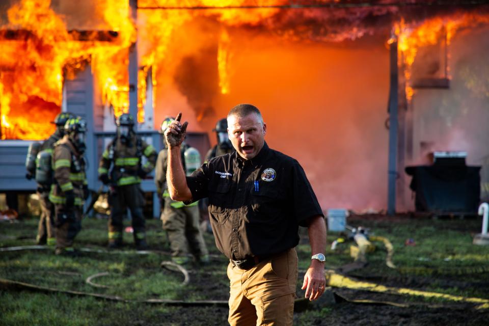 Dixie County Fire and Rescue Chief Darian Brown shouts to firefighters as the crew attempts to stop a home in Suwannee, Fla. from burning to the ground on Thursday, Aug. 31, 2023.