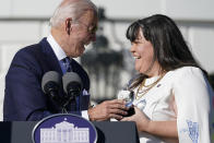 President Joe Biden, left, presents 2020 National Teacher of the Year Tabatha Rosproy, a preschool teacher from Kansas, with her award during an event for the 2020 and 2021 State and National Teachers of the Year on the South Lawn of the White House in Washington, Monday, Oct. 18, 2021. (AP Photo/Susan Walsh)