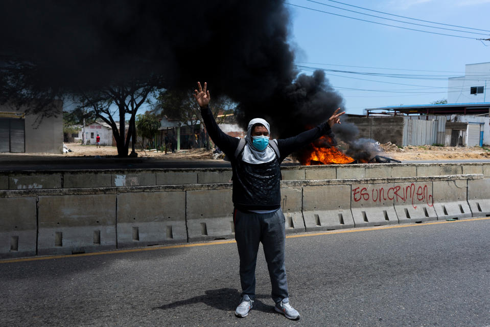 A protester raises his hands in the middle of clashes with the police in Barranquilla on May 1.<span class="copyright">Charlie Cordero—Reojo Colectivo</span>