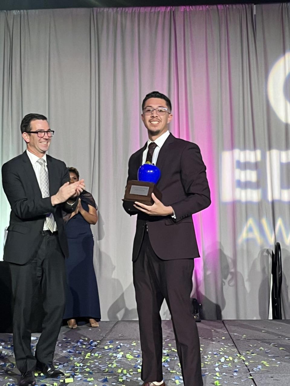 Terry Parker High School teacher Gustavo Guzman (right) displays the 2024 VyStar Teacher of the Year award as VyStar Credit Union President/CEO Brian Wolfburg applauds at the 33rd annual EDDY Awards.