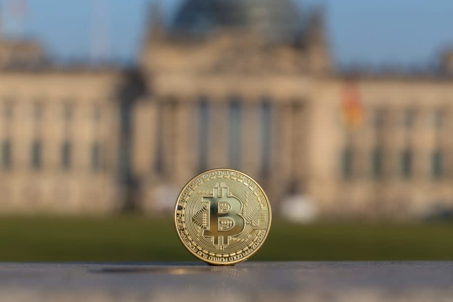 Ein Bitcoin steht senkrecht vor dem deutschen Bundestag.