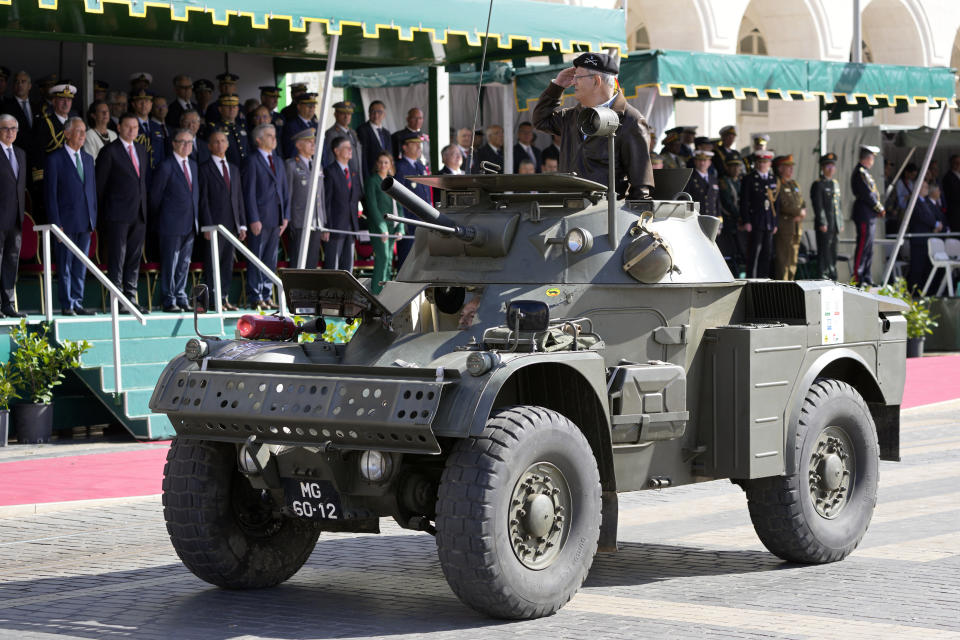 A former officer salutes from a military vehicle that took part in the 1974 Carnation revolution when driving past Portuguese President Marcelo Rebelo de Sousa, 2nd left, at Lisbon's Comercio square, Thursday, April 25, 2024, during celebrations of the fiftieth anniversary of the military coup. The April 25, 1974 revolution carried out by the army restored democracy in Portugal after 48 years of a fascist dictatorship. (AP Photo/Armando Franca)