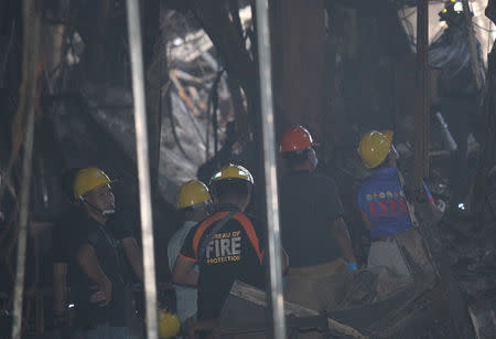 Fire investigators inspect a mall gutted by fire in Davao city, Philippines, December 29, 2017.REUTERS/Lean Daval Jr