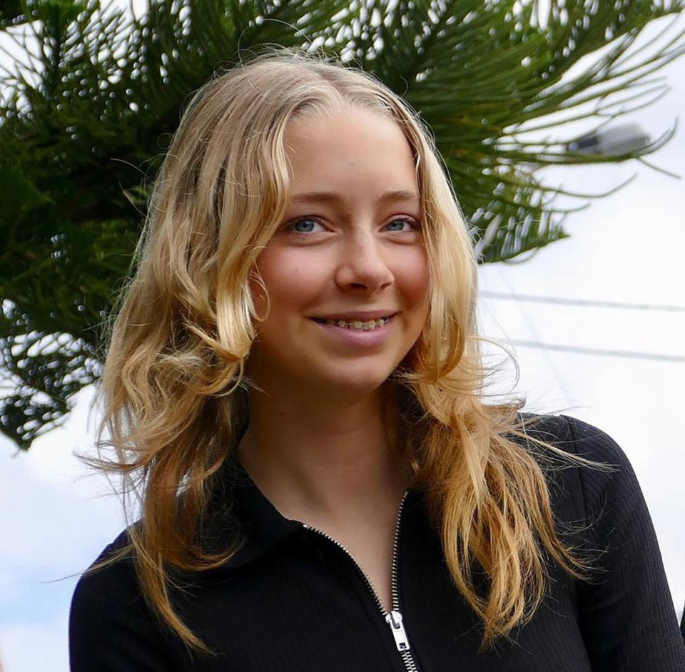 Maggie Banyard smiles at the camera with a tree in the background