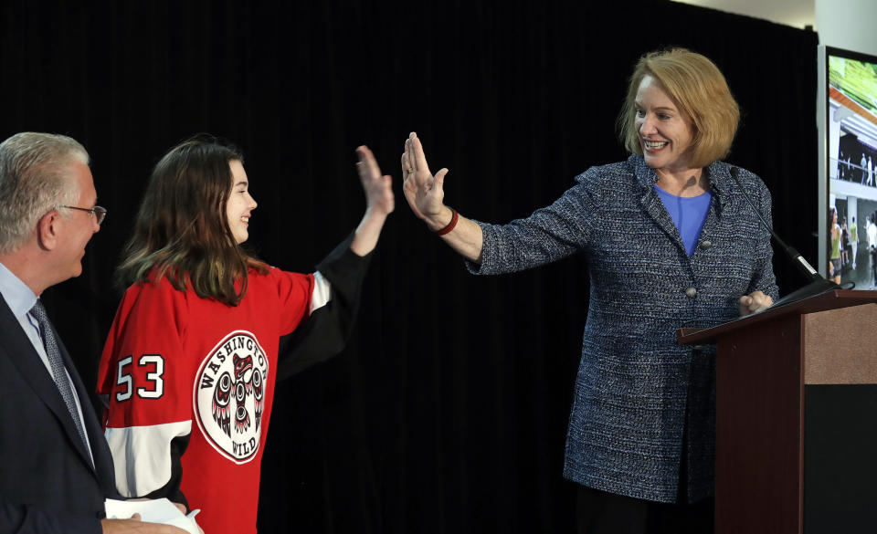 FILE - In this Oct. 8, 2018, file photo, Seattle Mayor Jenny Durkan, right, high-five's Washington Wild hockey team wing Jaina Goscinski, 11, as Tod Leiweke, CEO of NHL Seattle, looks on during a news conference in Seattle. The NHL Board of Governors is meeting, Tuesday, Dec. 4, 2018, in Sea Island, Ga., to give final approval to Seattle's bid to add the league's 32nd team. (AP Photo/Elaine Thompson, File)