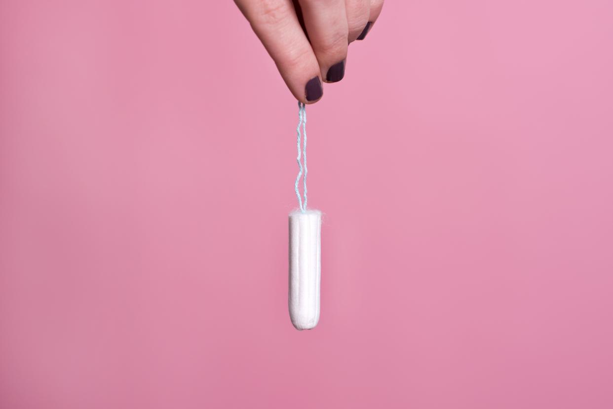 Woman's hand holding a clean cotton tampon