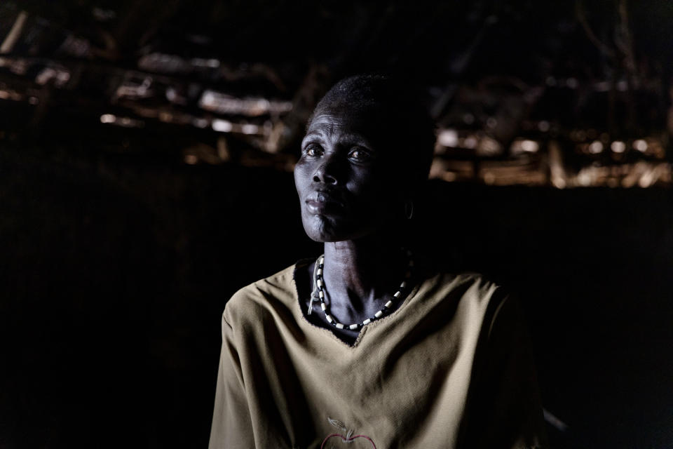 Ajou Bol Yel, who doesn't know her age, poses for a portrait in Langic, Northern Bahr el Ghazal State, South Sudan, Wednesday, Oct. 20, 2021. Yel's family of seven hosted nine neighbors who had lost their homes in the floods. The elders sleep outside on beds protected by mosquito nets, while the children share the Tukul's floor. The United Nations says the flooding has affected almost a half-million people across South Sudan since May. (AP Photo/Adrienne Surprenant)