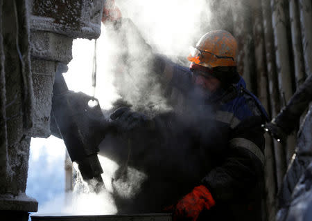 FILE PHOTO: Employees work on a drilling rig at the Rosneft company owned Samotlor oil field outside the West Siberian city of Nizhnevartovsk, Russia January 26, 2016. REUTERS/Sergei Karpukhin/File Photo