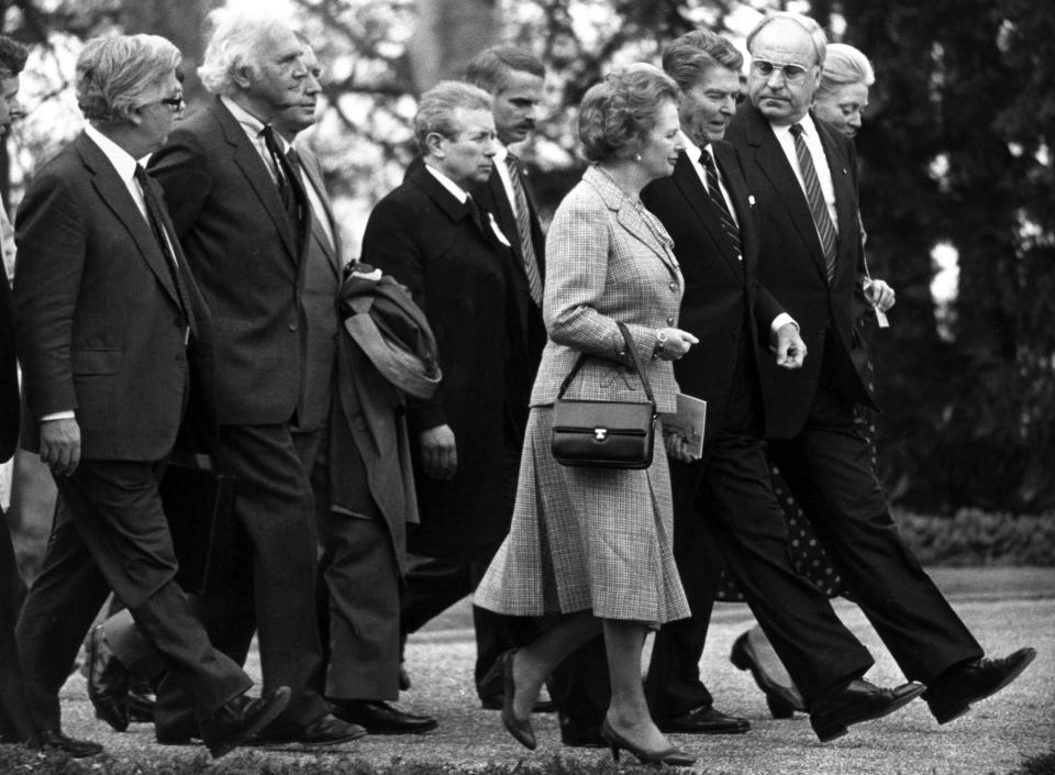 FILE - British Prime Minister Margaret Thatcher, US President Ronald Reagan walk with other politicians to an afternoon session of the World Economic Summit. Two people are running to be Britain’s next prime minister, but a third presence looms over the contest: Margaret Thatcher. Almost a decade after her death, the late former prime minister casts a powerful spell over Britain's Conservative Party. In the race to replace Boris Johnson as Conservative leader and prime minister, both Foreign Secretary Liz Truss and former Treasury chief Rishi Sunak claim to embody the values of Thatcher. (AP Photo/Helmuth Lohmann, File)