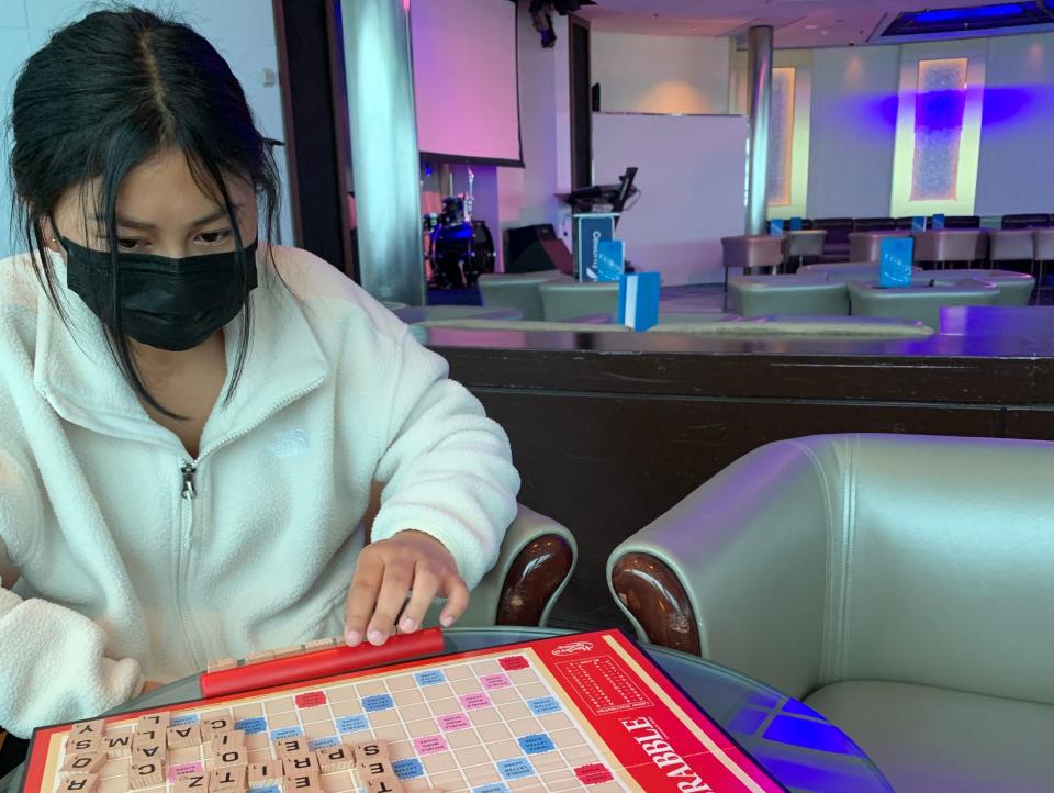 Person in white pullover playing a word game on cruise