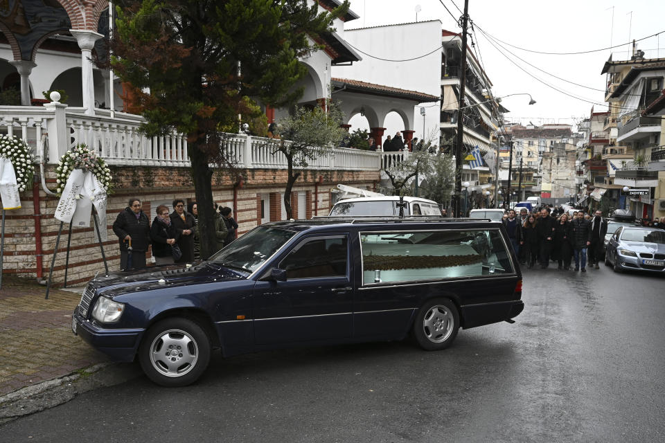 A hearse carrying the coffin of 23-year old Ifigenia Mitska arrives at a church, at Giannitsa town, northern Greece, Saturday, March 4, 2023. Over 50 people — including several university students — died when a passenger train slammed into a freight carrier just before midnight Tuesday. The government has blamed human error and a railway official faces manslaughter charges. (AP Photo/Giannis Papanikos)