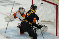 Boston Bruins left wing Jake DeBrusk (74) scores against Philadelphia Flyers goaltender Carter Hart (79) during a shootout in an NHL hockey game, Thursday, Jan. 21, 2021, in Boston. The Bruins won 5-4 in a shootout. (AP Photo/Elise Amendola)