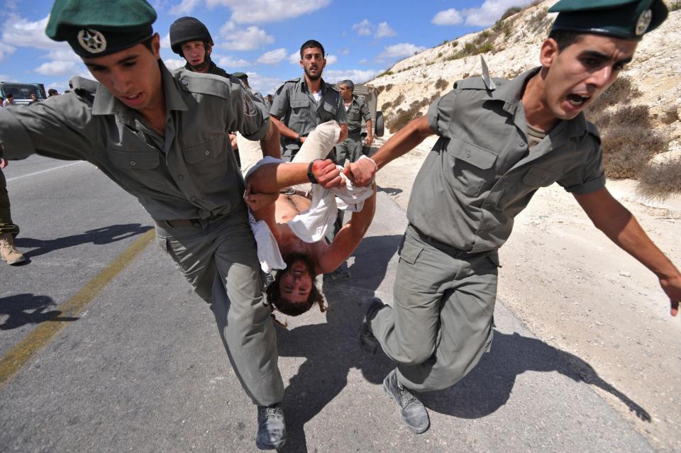 <span>Israeli settlers try to pull a fellow settler as he is dragged away by border policemen during clashes at the entrance to the illegal outpost of Havat Gilad, west of the occupied West Bank city of Nablus, after Israeli police tried to confiscate a truck containing material to build a new house on September 13, 2009.</span><div><span>YEHUDA RAIZNER</span><span>AFP</span></div>