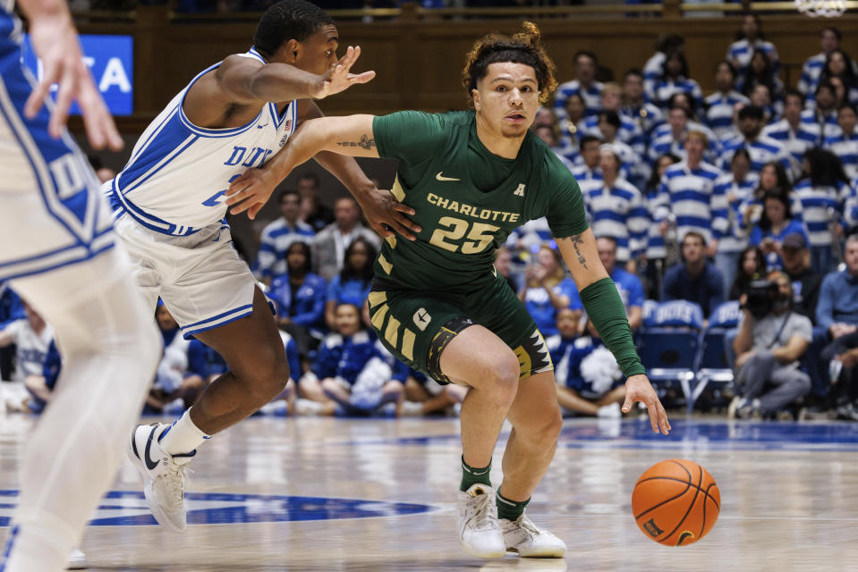 Charlotte's Lu'Cye Patterson (25) handles the ball as Duke's Jaylen Blakes (2) defends during the first half of an NCAA college basketball game in Durham, N.C., Saturday, Dec. 9, 2023. (AP Photo/Ben McKeown)