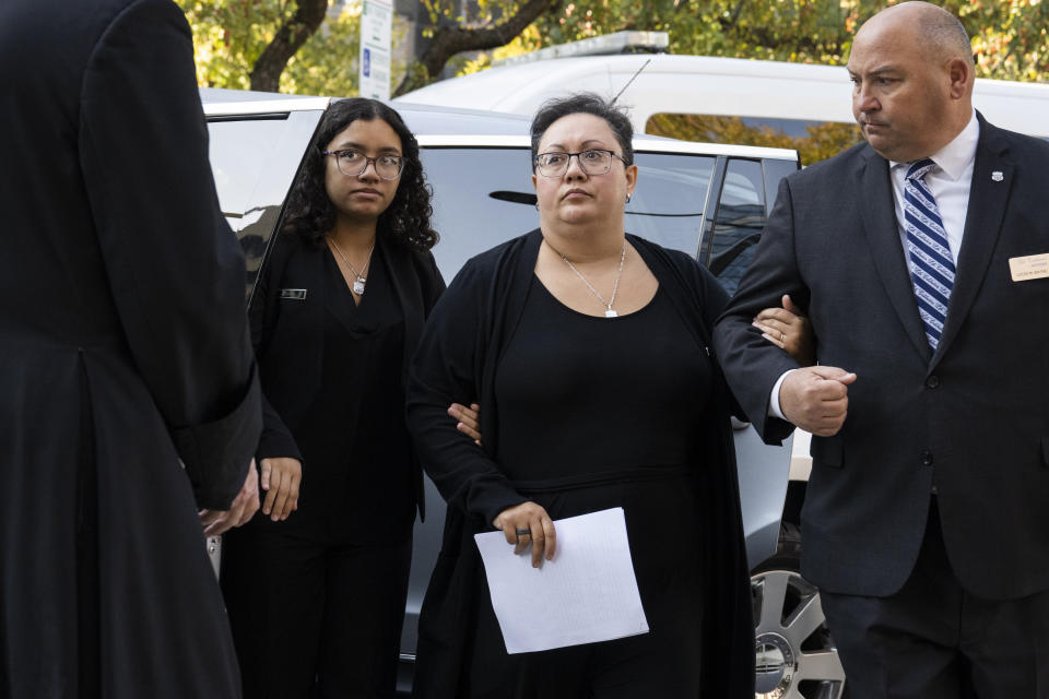 Alex Mendez, center, arrives for the viewing and funeral service for her husband, officer Richard Mendez, alongside their daughter Mia Mendez at the Cathedral Basilica of Saints Peter and Paul in Philadelphia, Tuesday, Oct. 24, 2023. Mendez was shot and killed, and a second officer was wounded when they confronted people breaking into a car at Philadelphia International Airport, Oct. 12, police said. (AP Photo/Joe Lamberti)