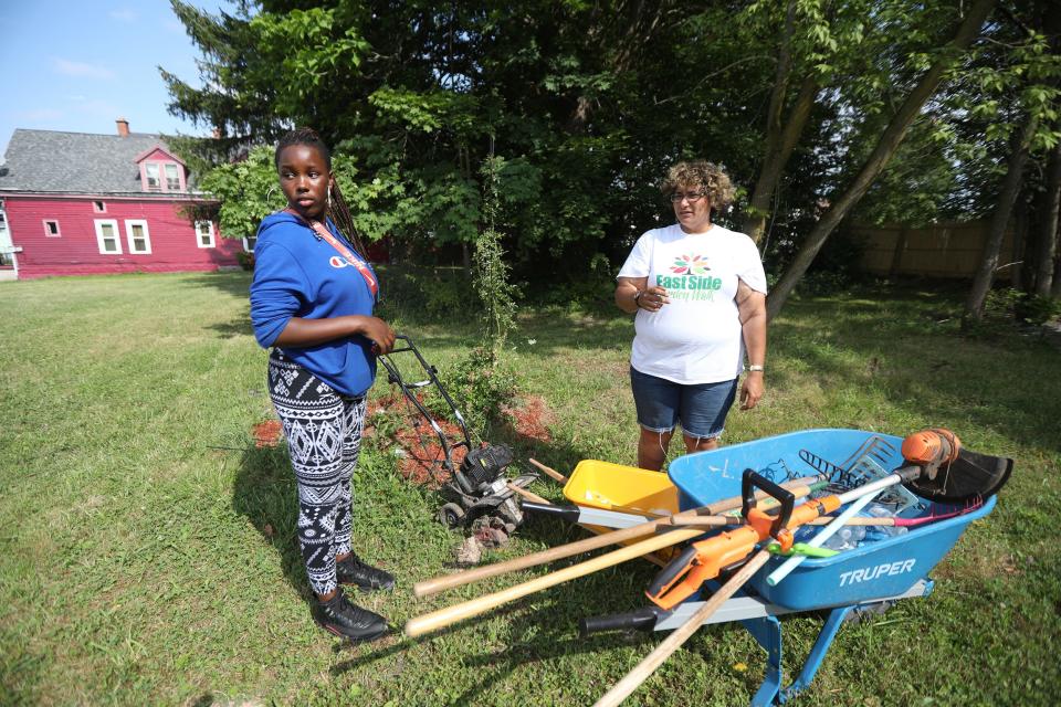 Juanita Hunter, a worker with the Mayor's Summer Youth Program, which provides summer jobs for youth, looks at a raised vegetable bed as Samantha White, Vice President of the Box Avenue Block Club, readies to pick vegetables to distribute to families on Buffalo's East Side. Hunter and White were working in the Box Avenue Block Club's Good Neighbors Garden on Thursday, July 28, 2022.