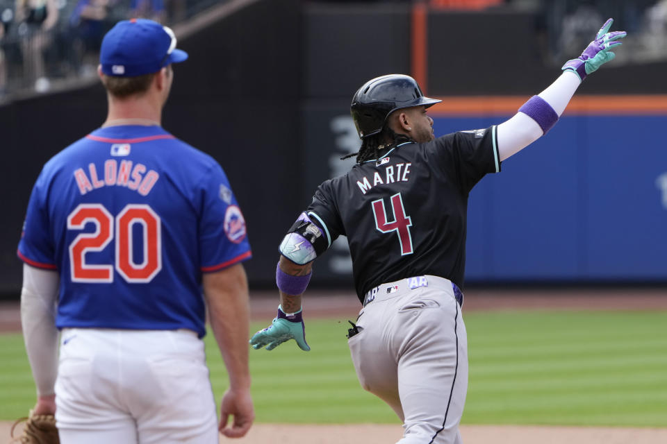 As New York Mets first baseman Pete Alonso, left, looks on, Arizona Diamondbacks' Ketel Marte , right, celebrates after hitting a two-run home run during the ninth inning of a baseball game against the New York Mets at Citi Field, Sunday, June 2, 2024, in New York. (AP Photo/Seth Wenig)