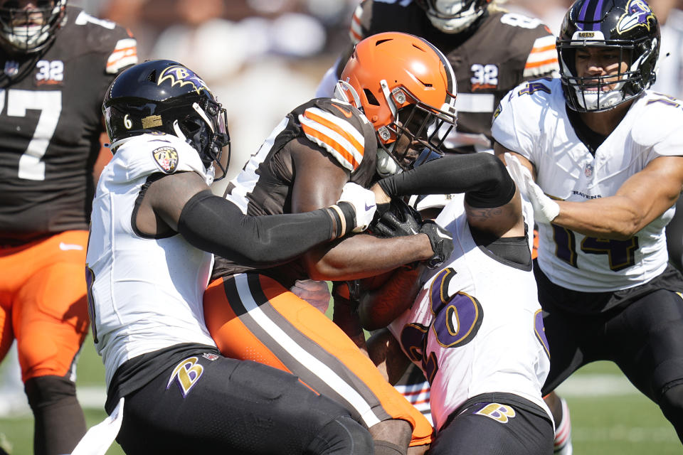 FILE - Cleveland Browns running back Jerome Ford is tackled by Baltimore Ravens linebacker Jeremiah Moon, left, and safety Geno Stone during an NFL football game, Oct. 1, 2023, in Cleveland. Deshaun Watson was safe on the sideline the last time the Browns played the Ravens. He'll be in harm's way on Sunday, Nov. 12, 2023. (AP Photo/Sue Ogrocki, File)