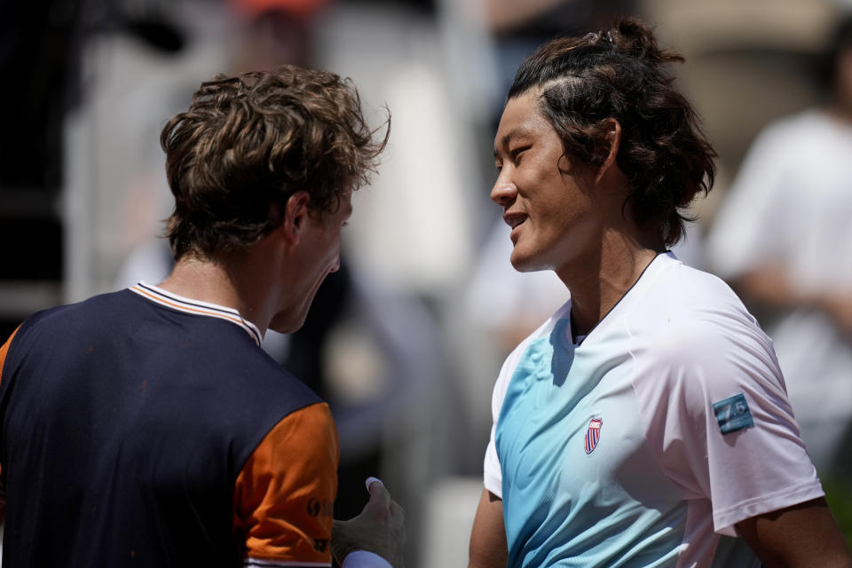 China's Zhang Zhizhen, right, shakes hands with Norway's Casper Ruud after their third round match of the French Open tennis tournament at the Roland Garros stadium in Paris, Saturday, June 3, 2023. (AP Photo/Christophe Ena)