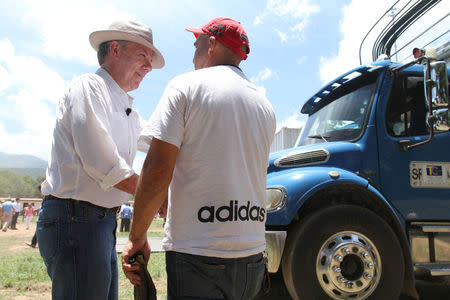 Colombia's President Juan Manuel Santos greets a driver carrying the last container with surrendered weapons delivered by FARC rebels to a UN observer in La Guajira, Colombia August 15, 2017. Colombian Presidency/Handout via REUTERS