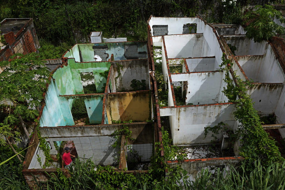 Paulo Sergio Doe visits abandoned homes in the Pinheiro neighborhood of Maceio, Alagoas state, Brazil, Sunday, March 6, 2022. Doe grew up in Pinheiros and refuses to abandon his home that is threatened by ground subsidence caused by the Braskem mine that has forced more than 55 thousand people from their homes in Maceio, even though he says that his friends have already left. (AP Photo/Eraldo Peres)