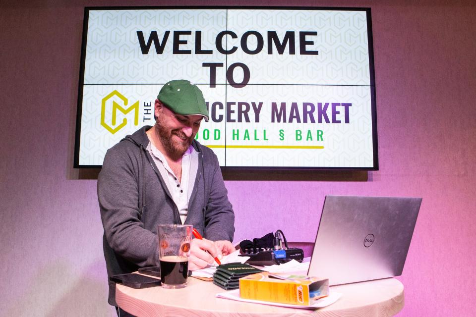 Lew Indellini checks a team's responses during Quizzo at The Chancery Market in Wilmington on Wednesday, March 15, 2023.