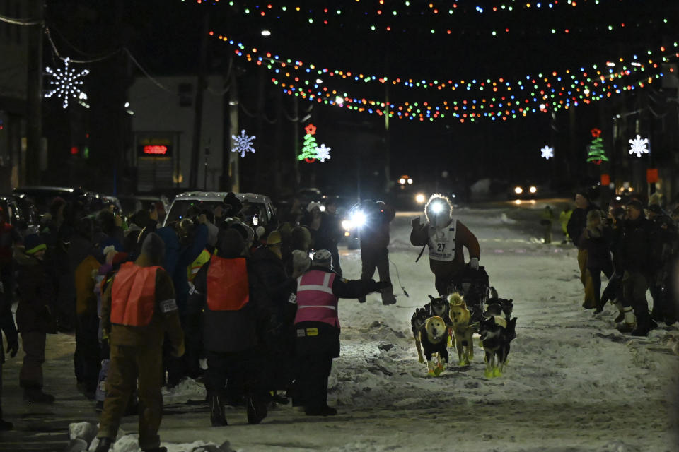Iditarod winner Brent Sass drives his team down Front Street in Nome, Alaska, on his way to the finish chute of the Iditarod Trail Sled Dog Race Tuesday, March 15, 2022. (Anne Raup/Anchorage Daily News via AP)