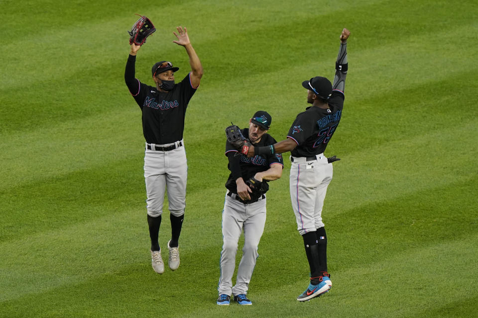 ADDS NAMES - From left to right, Miami Marlins left fielder Magnerius Sierra, right fielder Matt Joyce and center fielder Lewis Brinson celebrate after they shut out the New York Yankees in a baseball game Sunday, Sept. 27, 2020, at Yankee Stadium in New York. (AP Photo/Kathy Willens)