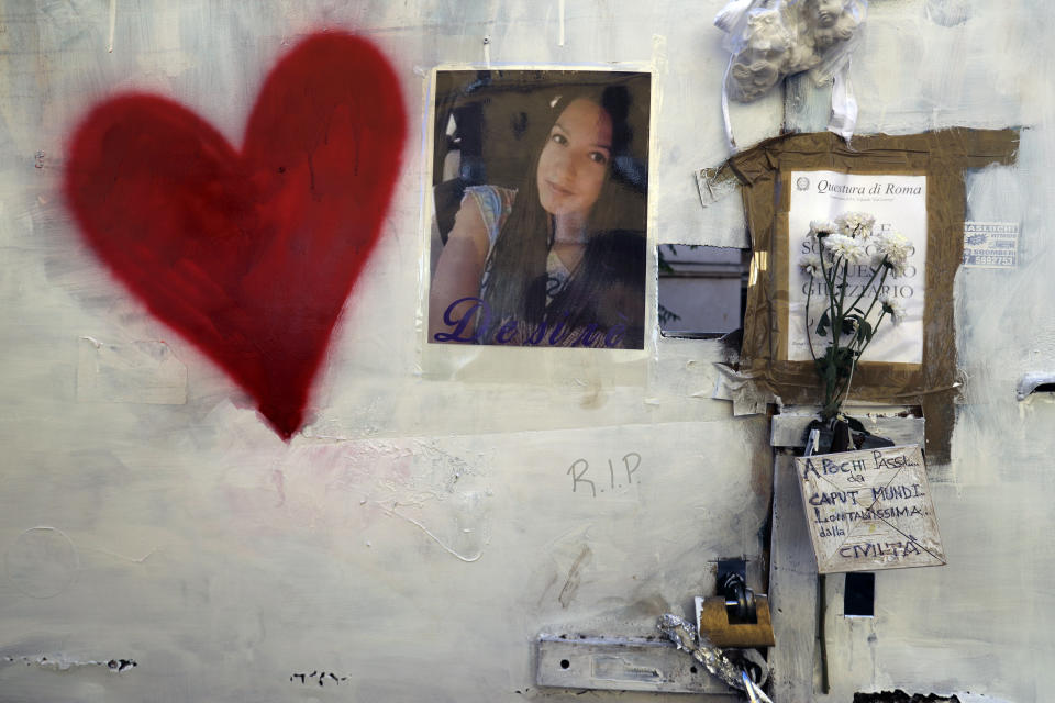 A picture of 16-year-old Desiree Mariottini hangs from a wall of the abandoned building where she was murdered, in Rome, Thursday, Oct. 25, 2018. Italian police have detained three suspects, all immigrants, in the slaying of a teenage girl who was drugged, gang-raped and left in an abandoned building known as a center for drug dealing in Rome. Authorities said Thursday that the three suspects, two Senegalese citizens and one Nigerian, were being held on suspicion of murder, group sexual assault and handing out drugs in the death late last week of 16-year-old Desiree Mariottini. (AP Photo/Gregorio Borgia)