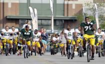Green Bay Packers players ride bikes to NFL football training camp Monday, July 28, 2014, in Green Bay, Wis. (AP Photo/Morry Gash)