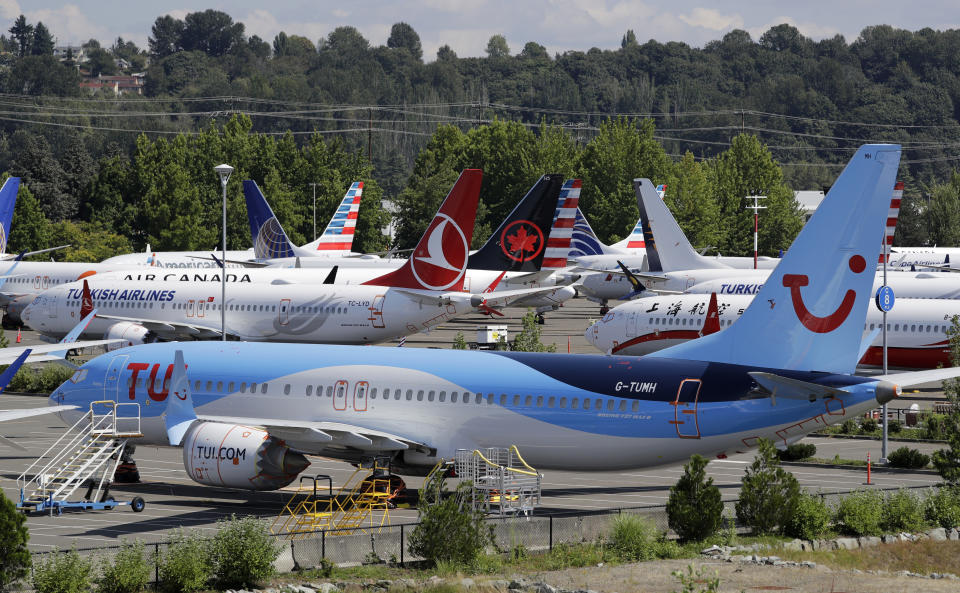 File-This Aug. 15, 2019, file photo shows dozens of grounded Boeing 737 MAX airplanes crowd a parking area adjacent to Boeing Field in Seattle. Boeing is settling more of the roughly 150 lawsuits filed by families of passengers killed in two crashes of the 737 Max jet. A Seattle law firm said Friday, Nov. 15, 2019, it settled four cases involving passengers on the Lion Air Max that crashed off the coast of Indonesia in October 2018. On Thursday, a judge approved settlements of nine other cases.(AP Photo/Elaine Thompson, File)