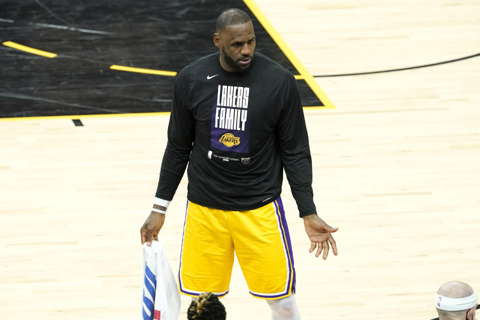 Los Angeles Lakers forward LeBron James speaks to his teammates on the bench during the second half of Game 5 of an NBA basketball first-round playoff series against the Phoenix Suns, Tuesday, June 1, 2021, in Phoenix. (AP Photo/Matt York)