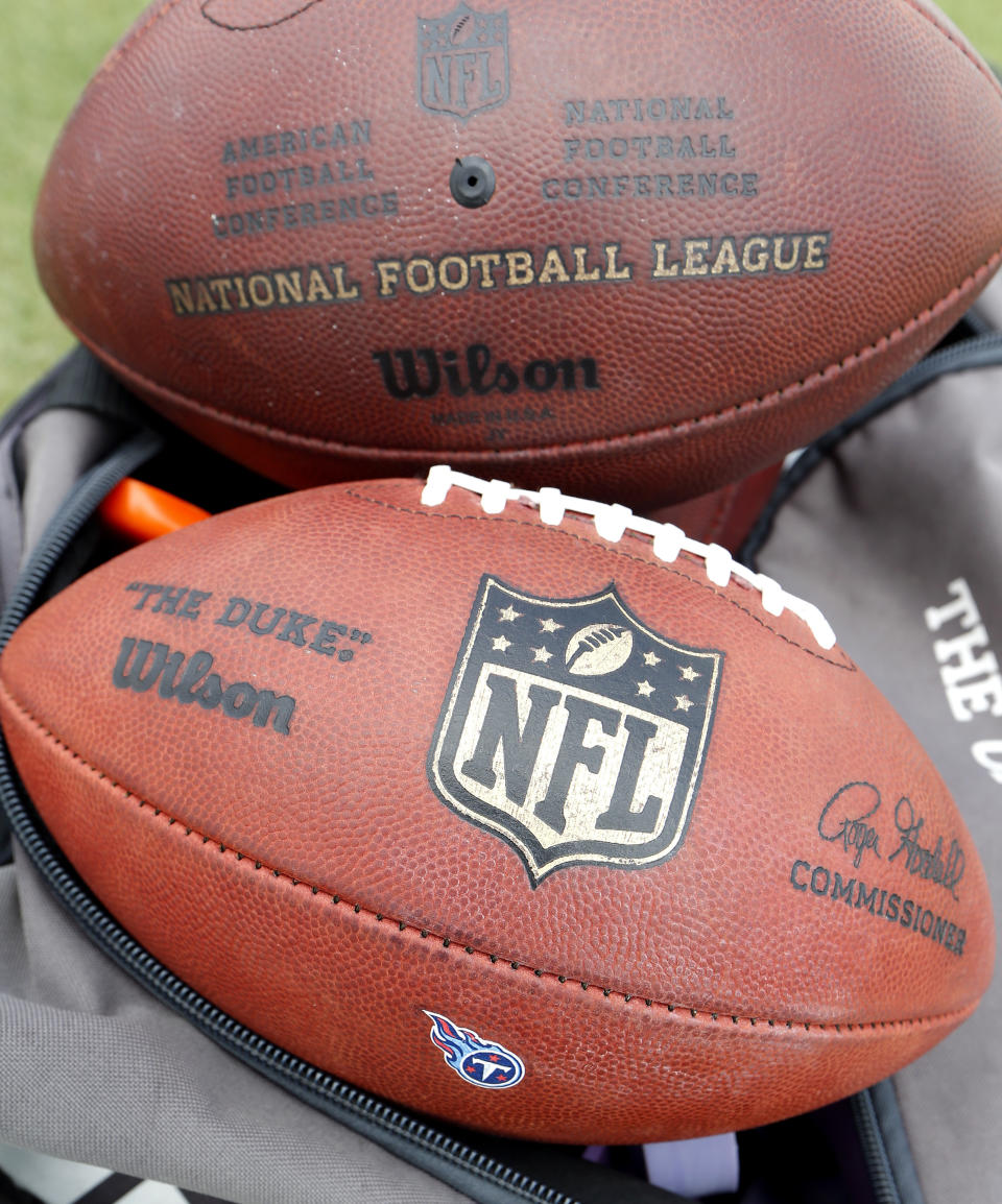FILE - In this July 27, 2018, file photo, footballs sit on a sideline during a Tennessee Titans NFL football training camp practice, in Nashville, Tenn. The four major pro sports leagues and the NCAA think that expanding legal betting will lead to more game-fixing. The architects of New Jersey’s successful legal challenge to the sports gambling ban say those fears are overstated and that bringing sports betting out of the shadows will make it easier to detect illegal activity.(AP Photo/Mark Humphrey, File)